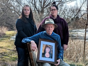 Flanked by his daughters Jocelyn Kaastra and Shannon Landreth, Doug Landreth sits on the memorial bench on the banks of the Harrington Pond the family dedicated to his wife, Louise Landreth, who was killed by a drunk driver in Burnaby BC in June 2019. (Galen Simmons/The Beacon Herald)