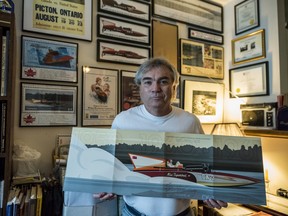 John Lyons poses inside his home as he holds a collectible folder made by Canada Post in recognition of Miss Supertest III's powerboating legacy. Lyons played a large role in the projects inception, petitioning Canada Post to begin the project. Sunday in Picton, Ontario. ALEX FILIPE
