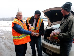 Don Coutts, left, Dave Clark and Bob Cunningham fill a car trunk with potatoes, Friday, at Manitoulin Transport in North Bay.
PJ Wilson/The Nugget