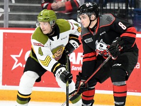Paul Christopoulos of the North Bay Battalion and Brenden Sirizzotti of the host Niagara IceDogs get up close in Ontario Hockey League action Saturday night. The Troops visit the Mississauga Steelheads Sunday.