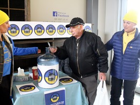 Peter Gallardi makes a donation to The Vest Project, Saturday, as Lori Burns, left, and  Cindie D'Agostino man a booth at Orchard's Fresh Food Market.
PJ Wilson/The Nugget