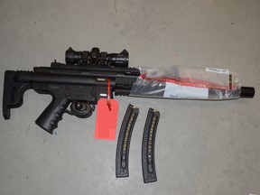 Police seized a semi-automatic rifle, along with two conducted energy weapons, a baton and brass knuckles, from a residence on Spruce Street where a man had holed up after assaulting his partner.