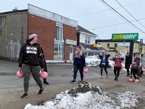 Members of Round Two Fitness carry their kettlebells 
from their current location to their new location on Saturday.  They are moving just down the road to 1060 Lorne St.