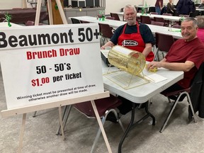 Volunteers Butch H. (on kitchen duty) and Firmin B. (on the right) are shown selling 50/50 tickets at the Beaumont 50+ Club brunch this month. (Beaumont 50+ Club)