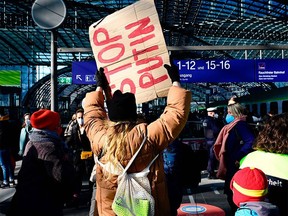 A person holds a placard reading "stop fucking" as she waits for a train with people arriving from Ukraine via Wroclaw in Poland as they fled Ukraine after Russia's invasion on Ukraine, on February 28, 2022 at Berlin's main station.