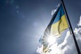 An ukrainian flag is lifted up during a gathering at the Department Hostel in Nantes, western France, on March 4, 2022, to support Ukraine after Russia's invasion. (Photo by Loic VENANCE / AFP) (Photo by LOIC VENANCE/AFP via Getty Images)