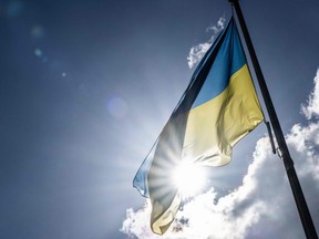 An ukrainian flag is lifted up during a gathering at the Department Hostel in Nantes, western France, on March 4, 2022, to support Ukraine after Russia's invasion. (Photo by Loic VENANCE / AFP) (Photo by LOIC VENANCE/AFP via Getty Images)