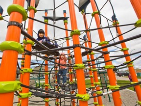 Tejas Singh, left and Lincoln Spragg have fun climbing at the Midtown playground in Airdrie on Saturday, May 23, 2020. Airdrie opened playgrounds on Friday after they were closed for about two months because of the COVID-19 pandemic. Gavin Young/Postmedia