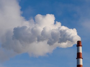 The pipe smokes against the blue sky.