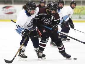 Wallaceburg Tartans' Taryn Jacobs, right, and Ursuline Lancers' Kailie DeCook battle for the puck in the second period of an LKSSAA girls' hockey game at Chatham Memorial Arena in Chatham, Ont., on Wednesday, March 2, 2022. Mark Malone/Chatham Daily News/Postmedia Network