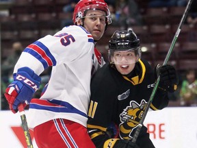 Sarnia Sting’s Zach Filak, right, is checked by Kitchener Rangers’ Justin Nolet in the first period at Progressive Auto Sales Arena in Sarnia, Ont., on Sunday, March 6, 2022. Mark Malone/Chatham Daily News/Postmedia Network