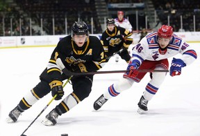 Sarnia Sting’s Ryan Mast (3) tries to elude Kitchener Rangers’ Simon Motew (46) in the first period at Progressive Auto Sales Arena in Sarnia, Ont., on Sunday, March 6, 2022. Mark Malone/Chatham Daily News/Postmedia Network