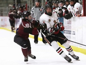Chatham Maroons' Colin Whaley, left, checks Sarnia Legionnaires' Ryder Nienhuis at Chatham Memorial Arena in Chatham, Ont., on Saturday, March 19, 2022. Mark Malone/Chatham Daily News/Postmedia Network