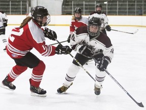 Wallaceburg Tartans' Sadie Farr, right, is checked by Lambton Central Lancers' Chloe Vanderzon during the LKSSAA 'A/AA' girls' hockey final at Wallaceburg Memorial Arena in Wallaceburg, Ont., on Thursday, March 24, 2022. Mark Malone/Chatham Daily News/Postmedia Network