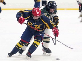 Chatham-Kent Golden Hawks' Paiton Desangher, left, and St. Patrick's Fighting Irish's Anderson Kozoil battle in the second period of the LKSSAA 'AAA' boys' hockey final at Pat Stapleton Arena in Sarnia, Ont., on Wednesday, March 30, 2022. (Mark Malone/Chatham Daily News)