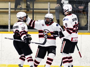 Malcolm McLeod (16) and Seth Huygen celebrate teammate Mark Cassidy's second period goal - the eventual winner - in the Mitchell Hawks' 3-0 win over Walkerton Feb. 26. ANDY BADER/MITCHELL ADVOCATE