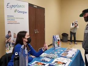 Ryan Preece visits a job fair in Owen Sound Thursday, shown here speaking with Georgian College representative Briar Robertson on Thursday, March 31, 2022. (Scott Dunn/The Sun Times/Postmedia Network)