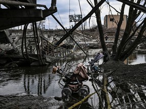 Abandoned strollers are pictured under a destroyed bridge as people flee the city of Irpin, west of Kyiv.