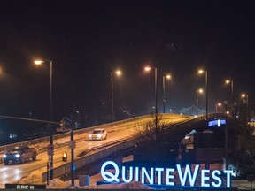 An illuminated Quinte West sign is seen beside the Dundas Street East bridge as motorists drive over it. Jan. 21 in Trenton, Ontario. ALEX FILIPE