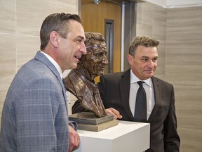 Brent Gretzky (left), and his brother Glen, pose for photos beside a bronze bust of their father Walter Gretzky, that was unveiled on Friday at City Hall in Brantford.