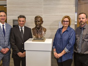 Brent Gretzky (left), his brother Glen, sister Kim, and Paris artist/sculptor Robert Dey stand beside a bronze bust of Walter Gretzky that was unveiled on Friday at city hall in Brantford.