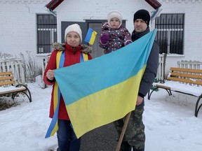 Yuliia Postil, her daughter Yeva, age 2, and husband Oleksandr Tykhomyrov stand in front of a community centre in the Poltava region of Ukraine where they are staying.