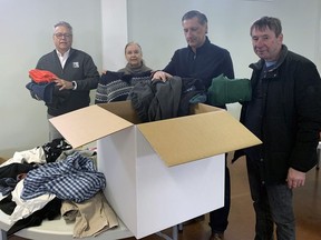 Steve Hudson, of Hudson Restoration in Brantford, Sharyl Hudson, Pastor Oleg Stepus o fthe Brantford Slavic Full Gospel Church, and Peter Kutz pack clothing into a box that will be shipped overseas in support of refugees who had to flee their home following Russia's invasion of Ukraine. Vincent Ball