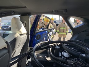 Brantford firefighter Tim Robinson removes a door from a vehicle during an auto extrication training session at No. 3 fire station on Lynden Road on Monday. Vincent Ball