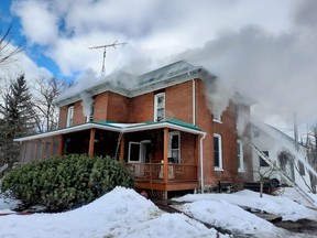 Smoke billows through the upper-storey windows of a home on County Road 5 Tuesday afternoon. Firefighters were unable to save the structure. (SUBMITTED PHOTO)