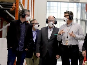 From left, Leeds-Grenville-Thousand Islands and Rideau Lakes MP Michael Barrett, Andrew Bowles, of 3M Canada's corporate team, and MPP Steve Clark listen to Rich Muir, 3M Canada's Brockville site manager, during a tour of the Brockville N95 respirator production plant on Thursday morning. (RONALD ZAJAC/The Recorder and Times)