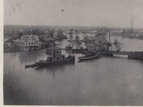 The great flood of 1868, two tug boats at centre and Fifth Street Bridge to the right. The North American Hotel is the white building at far left. John Rhodes