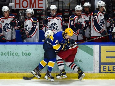 Carleton Place Canadians Gino Colangelo takes a Cornwall Colts player into the boards in front of the team's bench on Thursday March 24, 2022 in Cornwall, Ont. The Colts won 4-2. Robert Lefebvre/Special to the Cornwall Standard-Freeholder/Postmedia Network