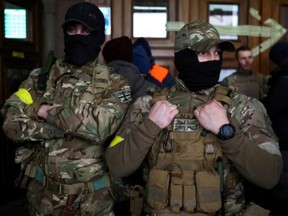 Two foreign fighters fom the U.K. pose for a photo as they prepare to depart to the front line in the east of Ukraine, following the Russian invasion. They're pictured at the main train station in Lviv, Ukraine, on March 5, 2022.