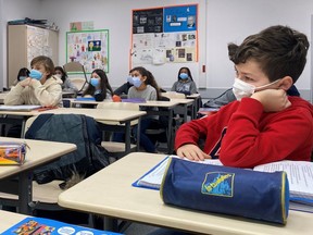 File: Schoolchildren, wearing protective face masks, work in a classroom at the College Jean Renoir Middle School in Boulogne-Billancourt, near Paris, France.