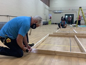 Gary Lees, manager of the Habitat for Humanity ReStore, assembles a sleeping pod for the new temporary Kingston Youth Shelter in MacGillivray-Brown Hall on Wednesday.