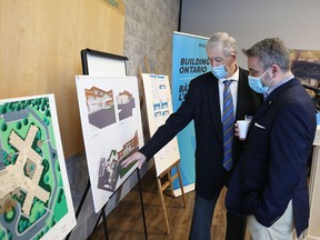 Hastings–Lennox and Addington MPP Daryl Kramp, left, and Paul Calandra, Ontario's long-term care minister, look at illustrations of three facilities in the Napanee area to be expanded and renovated, on Friday.