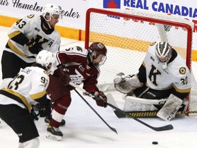 Kingston Frontenacs goaltender Aidan Spooner makes a save on Peterborough Petes forward Quinton Page as he's watched by Jake Murray and Maddox Callens during Ontario Hockey League action at in Peterborough on Thursday.