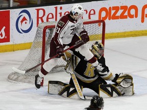 Brankár Kingston Frontenacs Leevi Merilainen sa pokúša o zákrok, keď Petes Chase Stillman z Peterborough skáče pred sieť v zápase Ontario Hockey League v Lyon Center v nedeľu popoludní.