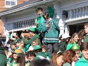 Revellers gather on a veranda during a large St. Patrick's Day street party in the Queen's University District at the corner of University Avenue and Johnson Street in Kingston on Thursday March 17 2022.