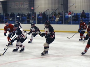 Kayden Varga took the puck for the Mustangs, flanked by teammates Dayne Cole and Reese Prutton.
