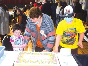 Photo by KEVIN McSHEFFREY
Darla Hennessey, who retired from the city on Dec. 31, 2021, cuts her retirement cake with two grandsons Elijah and Cameron on Saturday, March 19.