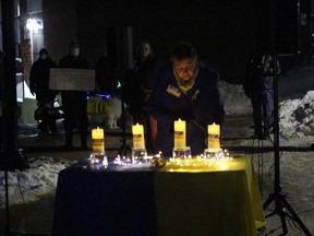 Rev, Lillian Roberts lights a candle at a vigil for peace, Friday night, at North Bay City Hall.
PJ Wilson/The Nugget