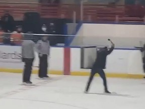 A minor hockey coach is shown whipping a broken stick blade toward two referees in a cellphone video taken during a game at Talbot Gardens in the Southwestern Ontario town of Simcoe on March 2, 2022. Screengrab