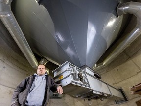 Jake Dietrich stands at the base of a massive concrete hopper that currently holds about 67,000 bushels of winter wheat at their corn, bean and grain storage facility near Lucan. Mike Hensen/Postmedia