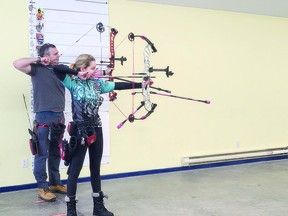David Maich and Anya Pinel pose on the archery range in the Sault.