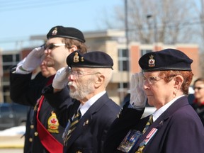 Saluting during a vigil for Ukraine held Sunday in the parking lot of the Branch 216 Royal Canadian Legion in Petrolia are, from left, Phillip Laker, Walt Nicholls and legion zone commander Laura Nicholls.