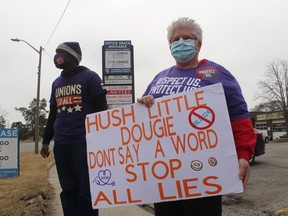 Sandra Jamieson, co-chairperson for SEIU Healthcare at Bluewater Health, holds a sign during a union rally Friday outside the constituency office of Sarnia-Lambton MPP Bob Bailey.