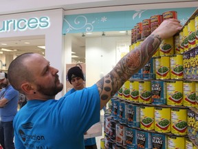 Colin Mertick with a team from Pembina works on its structure Saturday at Canstruction held at Lambton Mall. The event raises food and cash donations for the Inn of the Good Shepherd food bank.