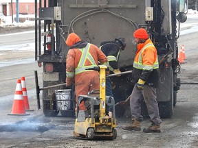 A work crew from Bruce Tait Construction Ltd. repairs a section of road on Notre Dame Avenue. Pothole-patching crews have been dispatched all over the city to address the roads.