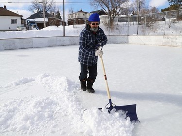 Vic Desormeaux shovels snow off the rink at Antwerp Playground in Sudbury, Ont. on Friday March 11, 2022. John Lappa/Sudbury Star/Postmedia Network